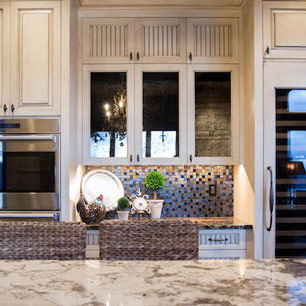 Kitchen featuring antique mirror, marble, custom cabinets, Wolf and SubZero appliances and glass tile